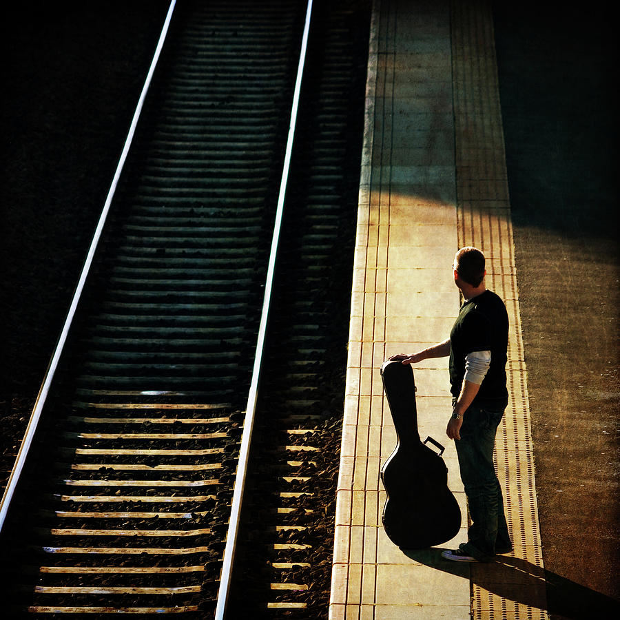 Man With Guitar At Station Photograph by Chris Conway