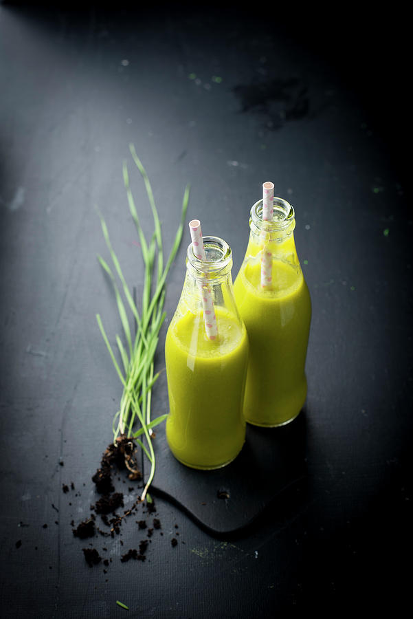 Mango And Wheatgrass Smoothies In Glass Bottles Photograph by Manuela Rther