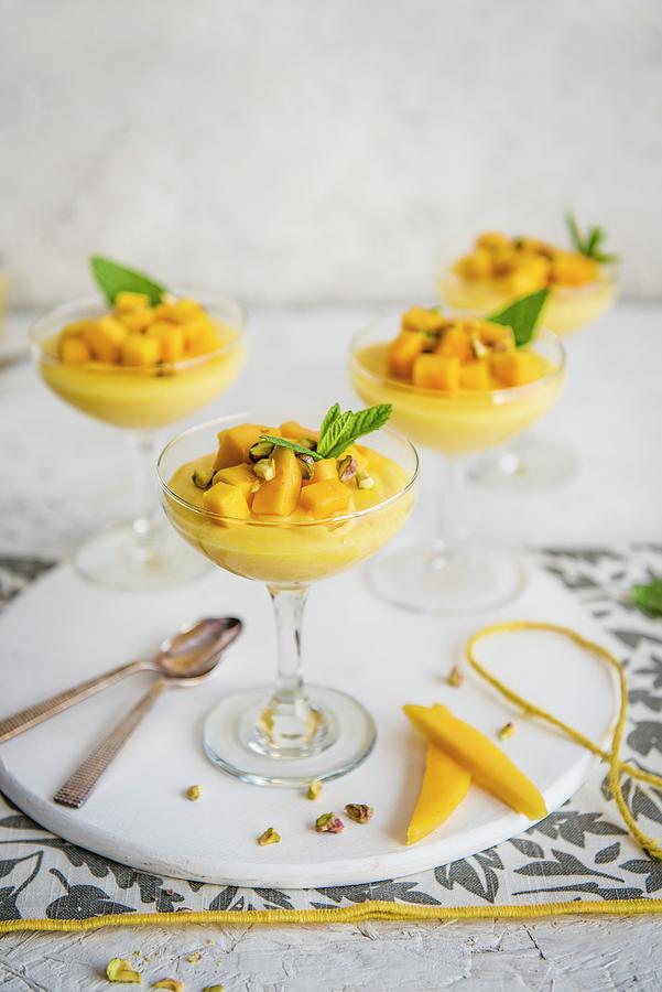 Mango Mousse In Stem Glasses With Mango Chunks, Pistachio Nuts And Fresh Mint Photograph by Magdalena Hendey