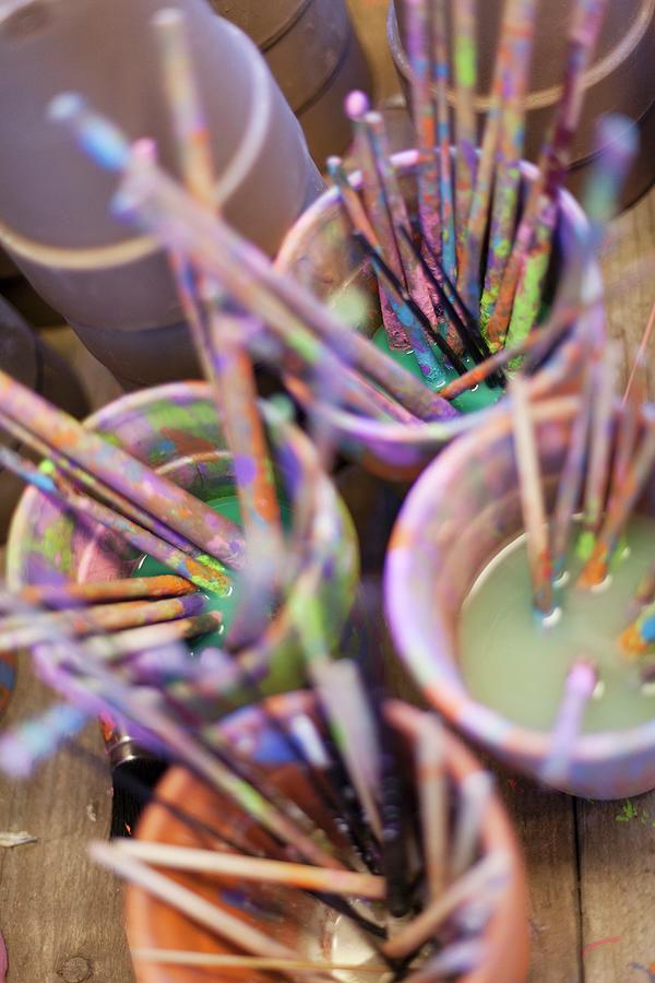 Brush Photograph - Many Paint-stained Paintbrushes Soaking In Pots Of Water by Jansje Klazinga