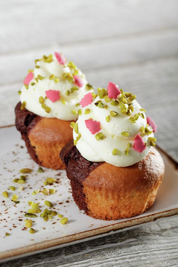 Marble Cupcakes Topped With White Cream, Pistachios And Pink Sugar Christmas Trees Photograph by Niklas Thiemann