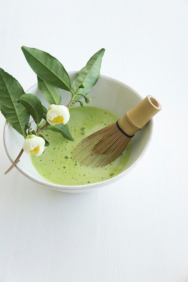 Matcha Tea With A Bamboo Whisk In A Tea Bowl On A White Surface Photograph by Martina Schindler