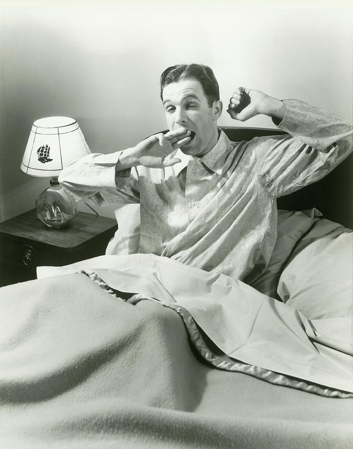 Mature Man Yawning Sitting In Bed Photograph by George Marks