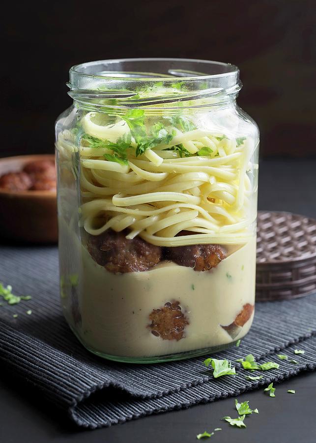 Meatballs And Tagliatelle In A Glass Jar With Soy Cream And Fresh Parsley Photograph by Etienne Voss