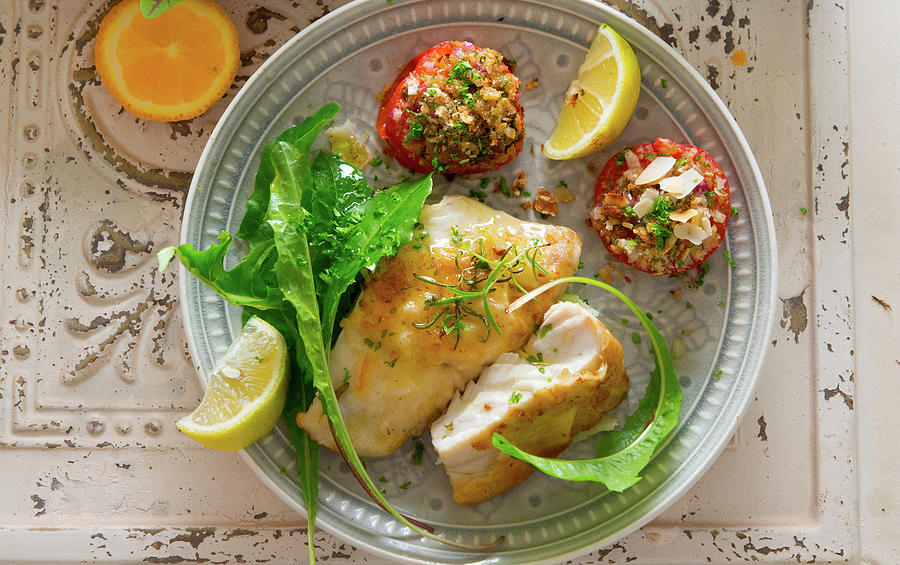 Mediterranean Coalfish Served With Stuffed Tomatoes And A Dandelion Salad Photograph by Udo Einenkel