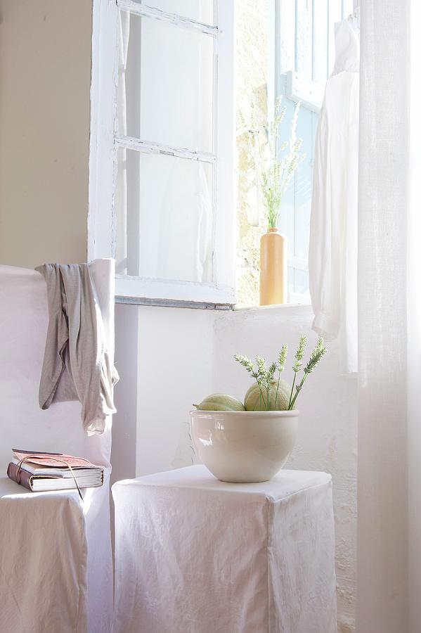 Melons And Flowers In White Bowl On Loose-covered Stool Below Open Window Photograph by Nele Braas