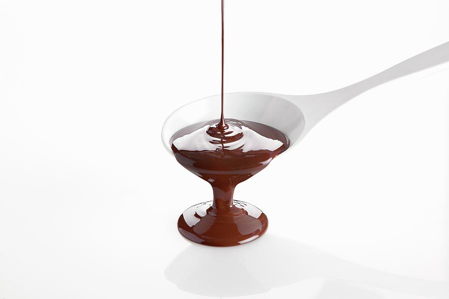 Melted Chocolate Pouring From A Cooking Spoon Photograph by Pizzi, Alessandra