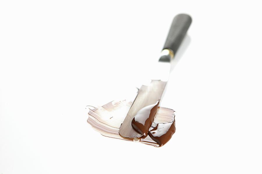 Melted Cooking Chocolate Being Spread With A Palette Knife Photograph by Pizzi, Alessandra