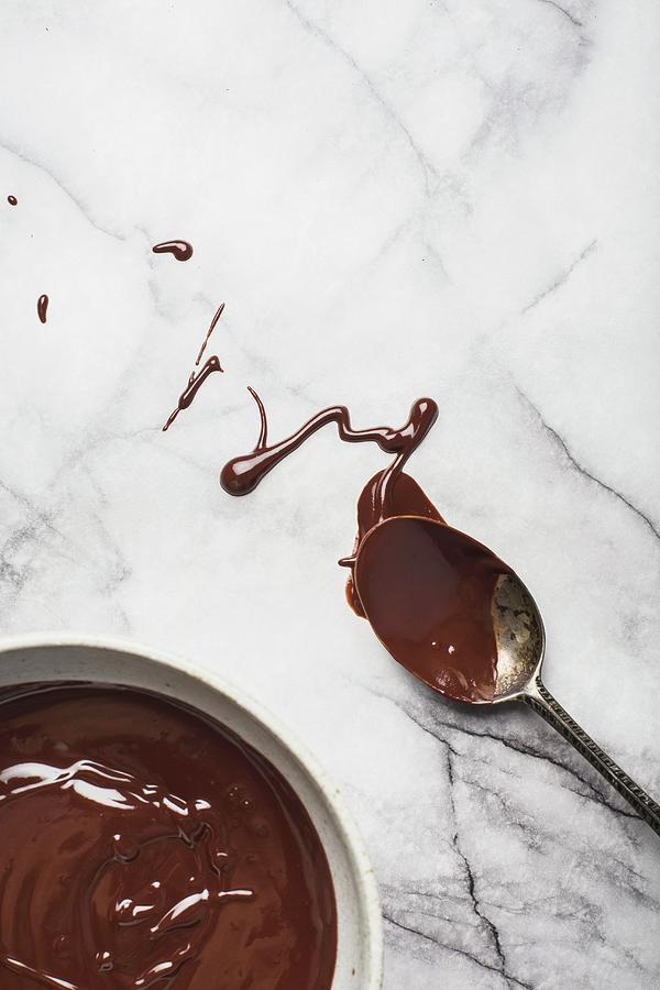 Candy Photograph - Melted Dark Organic Chocolate In A Bowl And Spoon On A Marble Surface by Rose Hewartson