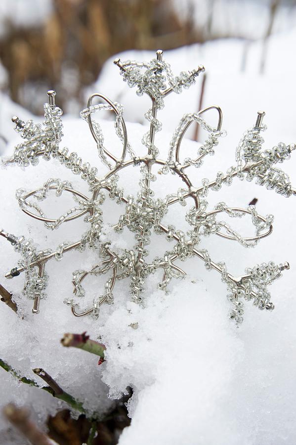 Metal And Rhinestone Snowflake Ornament Lying In Snow Photograph by Martina Schindler