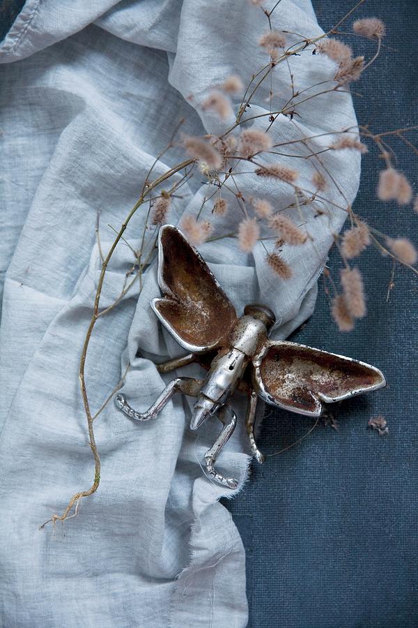 Metal Insect Figurine On Blue Fabric Photograph by Alicja Koll