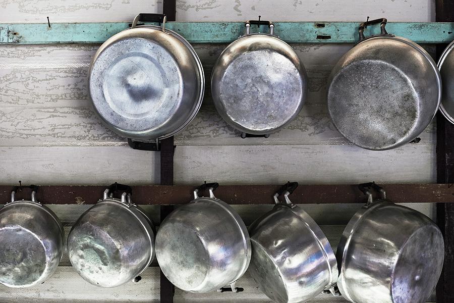 Metal Pots Hanging On A Wooden Wall Photograph by Ulf Svane