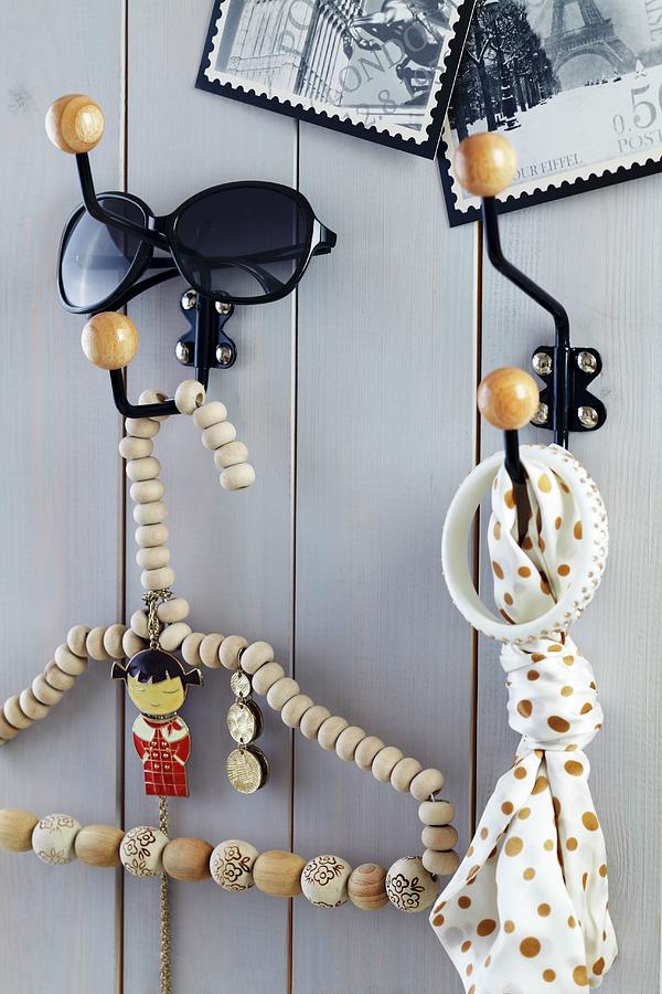 Metal Wall Hooks With Round Wooden Ends On Wooden Wall And Coathanger Threaded With Wooden Beads Photograph by Franziska Taube