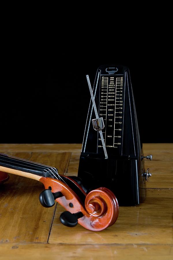 Metronome And Violin On Wooden Table Photograph by Junior Gonzalez