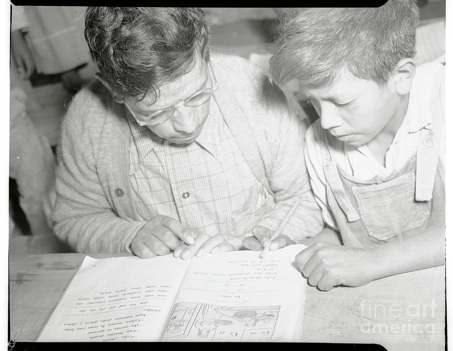 Mexican Parent And Son Reading From Book Photograph by Bettmann