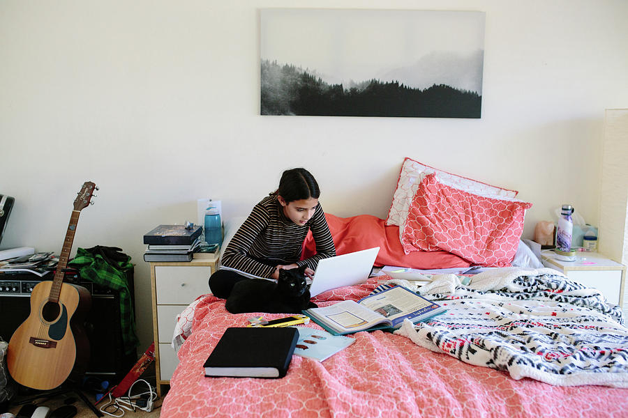 Cat Photograph - Middle School Girl Sits With Her Cat While Online Learning On Her Bed by Cavan Images