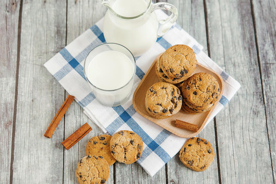 Milk In A Jar And A Jug, With Chocolate Chip Cookies And Cinnamon Sticks Photograph by Kuzmin5d
