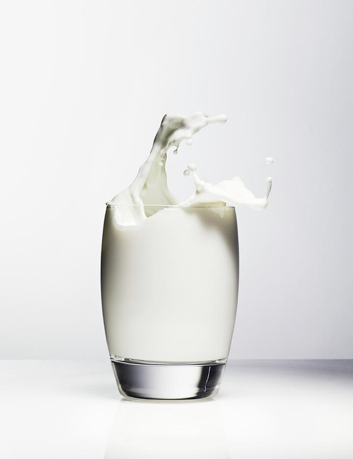 Milk Splashing Out Of Drinking Glass Photograph by Henrik Sorensen