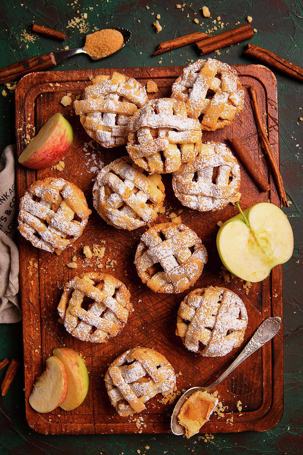 Mini Apple Pies With Cinnamon And Sugar Powder On A Wooden Board Photograph by Karolina Polkowska