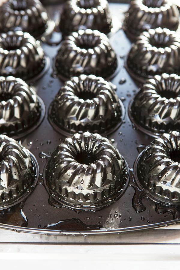 Mini Bundt Cake Moulds On A Baking Tray Photograph by Anneliese Kompatscher