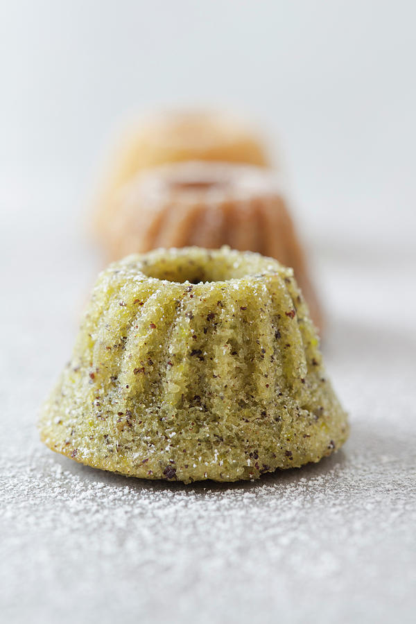 Mini Bundt Cakes With Pistachio Nuts, Poppyseeds And Icing Sugar Photograph by Jan Wischnewski