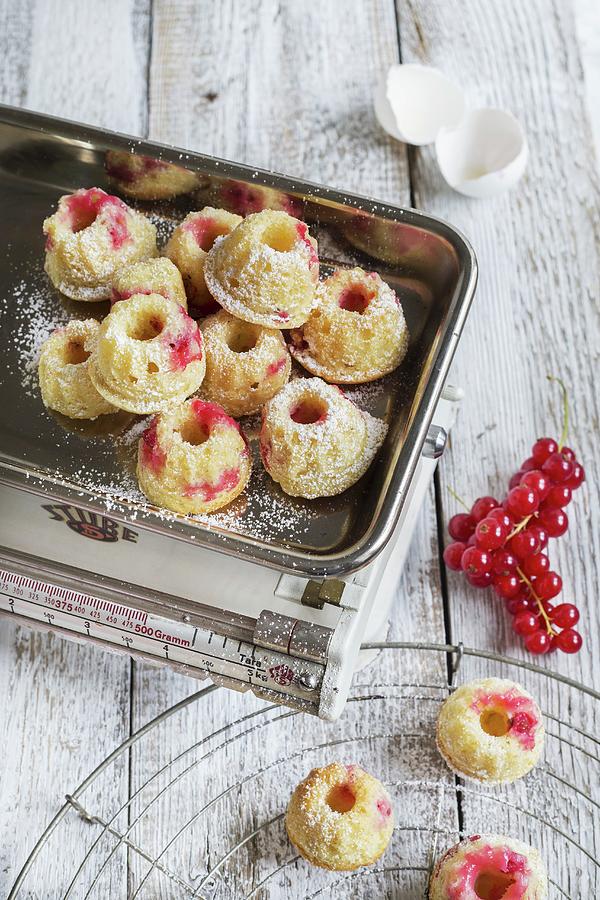 Mini Bundt Cakes With Redcurrants On A Pair Of Kitchen Scales With A Sprig Of Fresh Redcurrants Next To It Photograph by Tina Engel