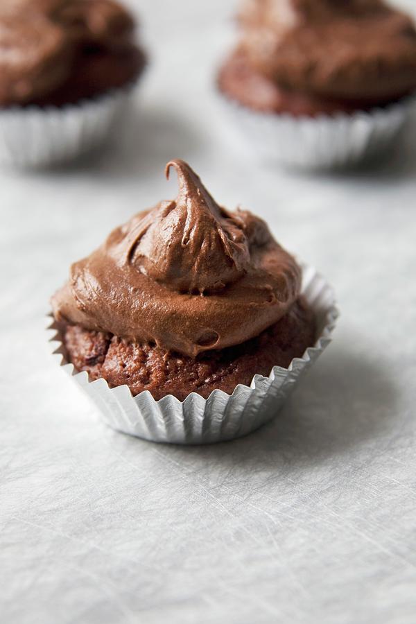 Mini Chocolate Cupcake With Chocolate Frosting In A Foil Wrapper Photograph by Joy Skipper Foodstyling