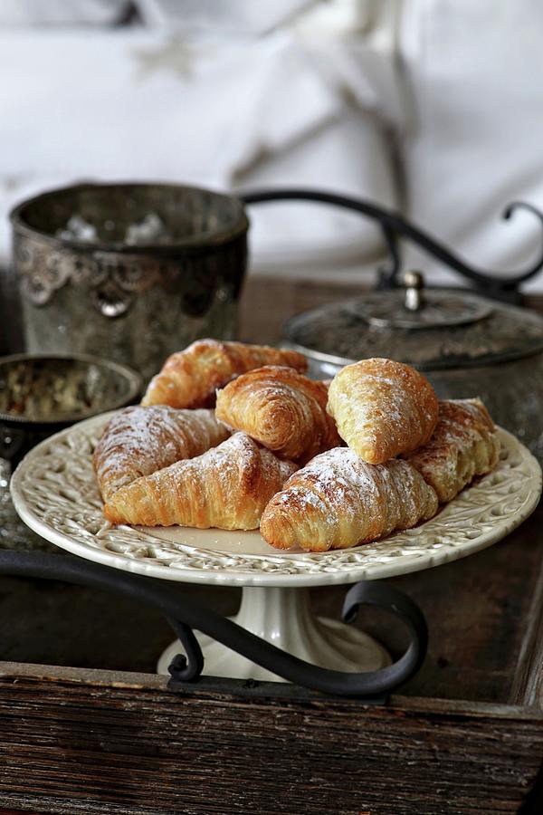 Mini Croissants On A Vintage Cake Plate On A Wooden Tray With Decorations Photograph by Alexandra Panella