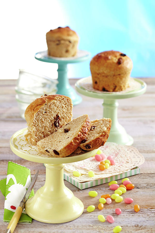 Mini Easter Buns With Sultanas On Coloured Cake Stands Photograph by Teubner Foodfoto