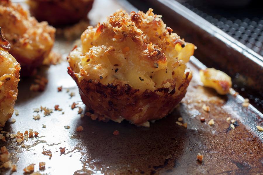 Mini Macaroni And Cheese Cakes With Prosciutto On A Baking Tray Photograph by Katharine Pollak