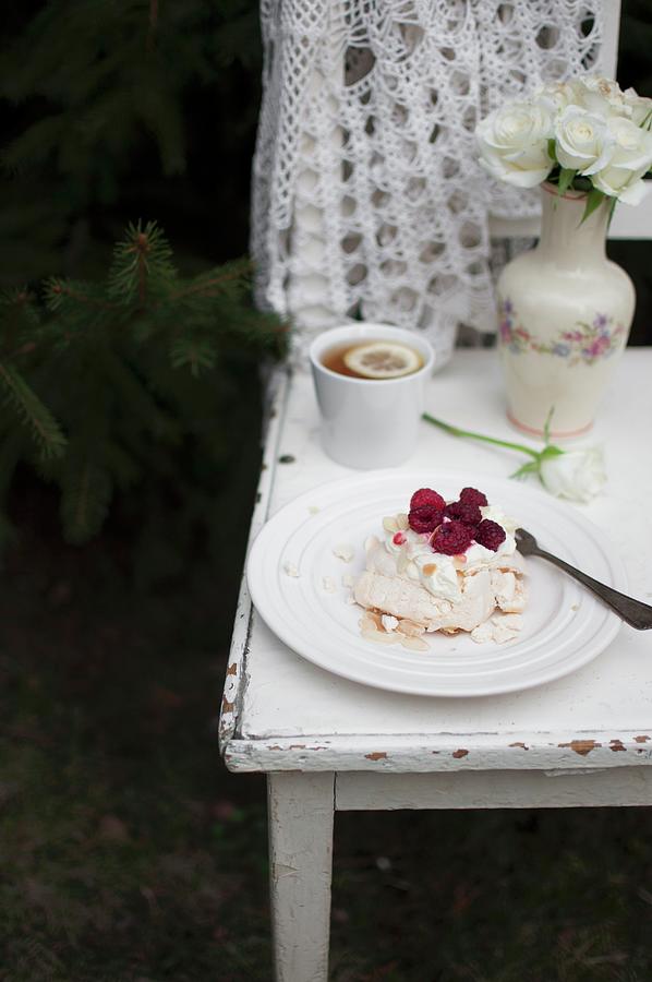 Mini Pavlova meringue Cake With Whipped Cream, Raspberries And Almond Flakes, Served In The Garden With Cup Of Tea Photograph by Kachel Katarzyna