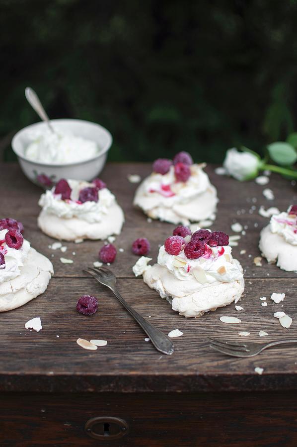 Mini Pavlova meringue Served With Whipped Cream, Raspberries And Almond Flakes Photograph by Kachel Katarzyna