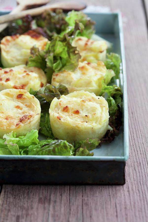 Mini Potato Gratin On A Bed Of Lettuce Leaves Photograph by Martina Schindler