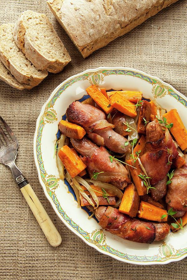 Mini Sausages Wrapped In Bacon With Sweet Potatoes And Bread Photograph by Adrian Britton