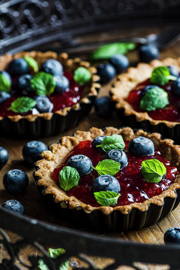 Mini Tarst With Strawberry Jam And Blueberiies. Decorated With Mint Leaves Photograph by Mateusz Siuta