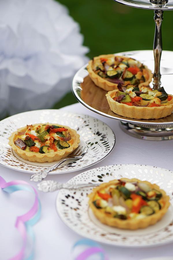 Mini Vegetable Quiches On A Silver Stand And Plates Photograph by Winfried Heinze