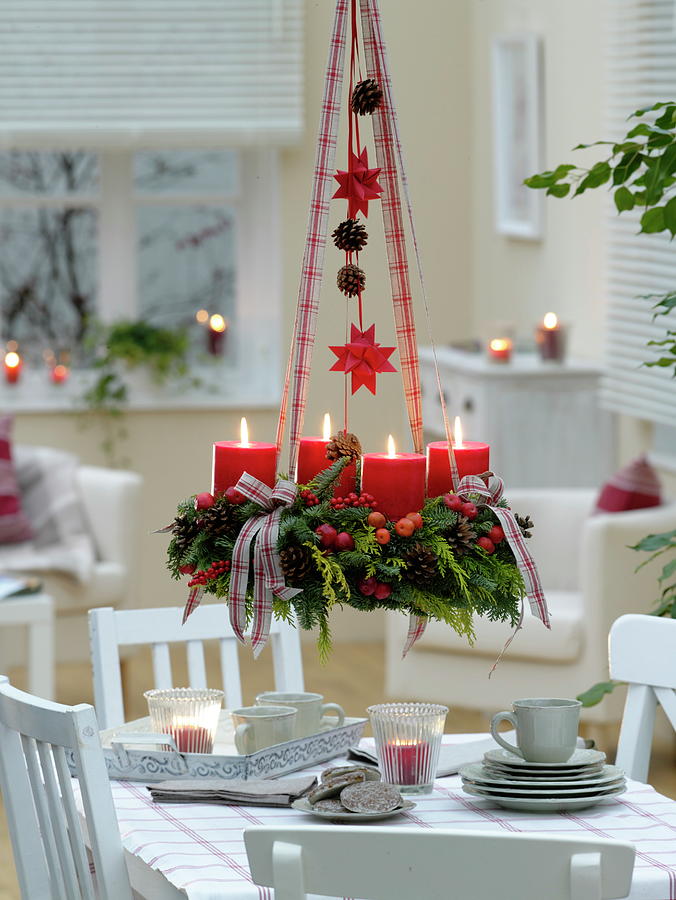 Mixed Christmas Wreath With Red Candles Hung Over The Table Photograph by Friedrich Strauss