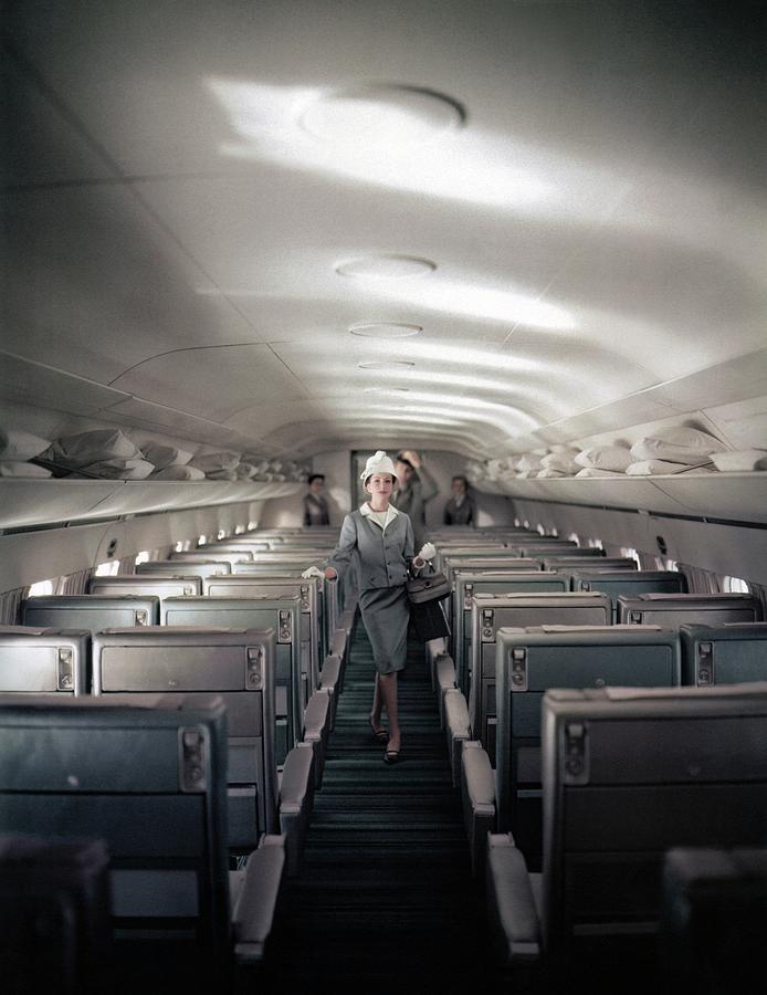 Model Walking Down An Airplane Aisle Photograph by John Rawlings