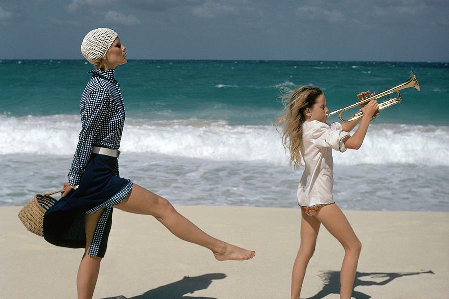 Model With Young Trumpeter On The Beach Photograph by Gianni Penati