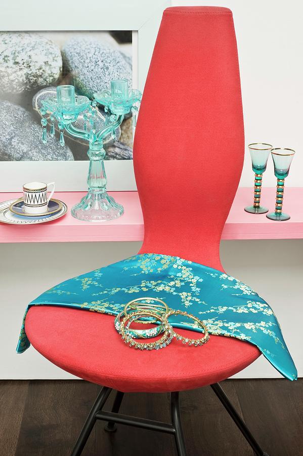 Modern Chair Decorated With Bangles And Silk Scarf In Front Of Glassware On Shelf Photograph by Linda Burgess