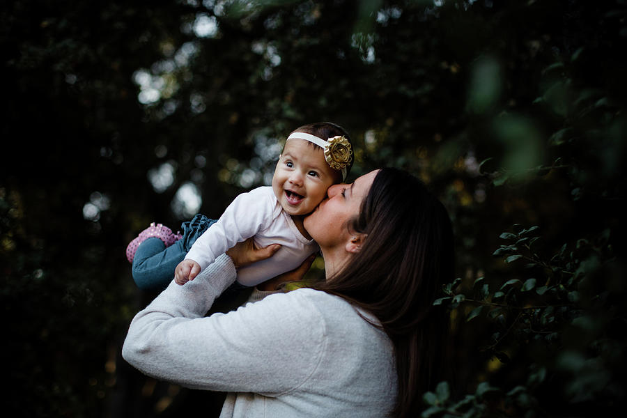 Fall Photograph - Mom Kissing Daughter As Baby Laughs by Cavan Images