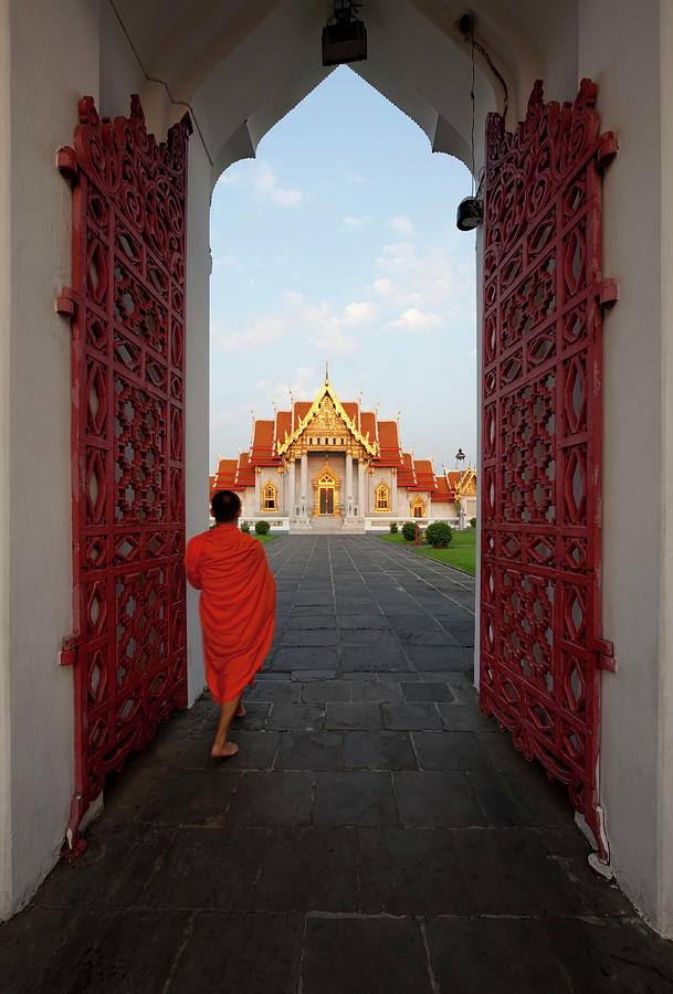 Monk Walking Through The Entrance Photograph by Enviromantic