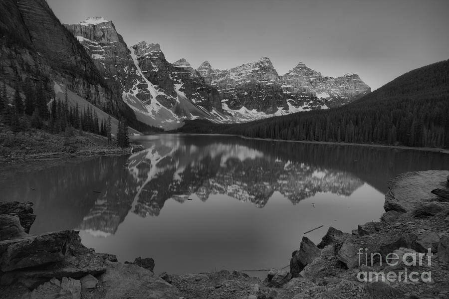 Moraine Lake Sunrise Reflections Over The Rocks Black And White Photograph by Adam Jewell