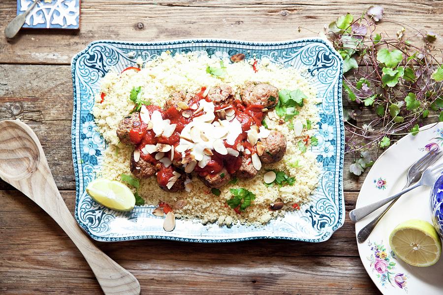 Moroccan Lamb Meatballs On A Bed Of Couscous With Tomato Sauce, Yoghurt And Almonds Photograph by George Blomfield