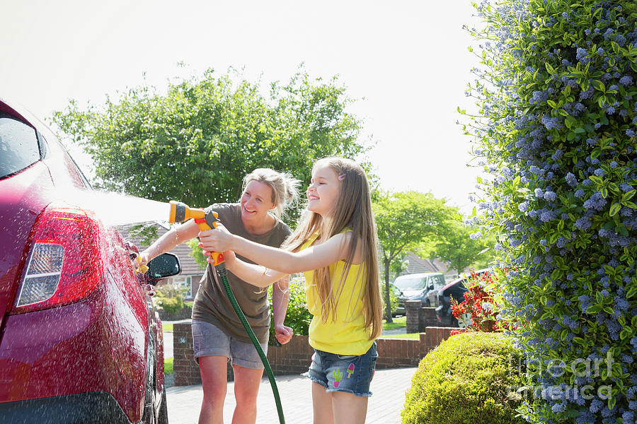 Mother And Daughter Washing Car In Sunny Driveway Photograph By Caia