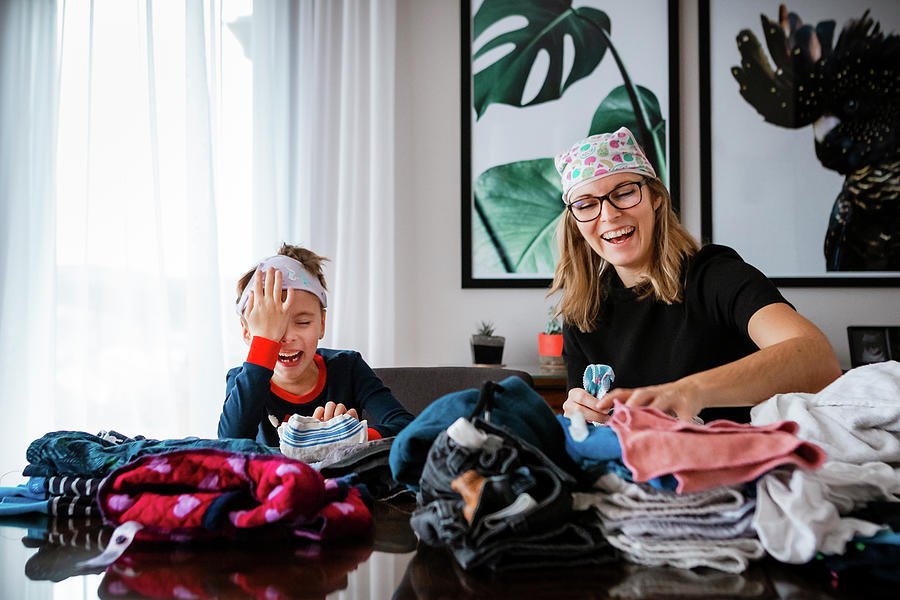 Mother And Son Folding Clothes With Underwear On Their Head