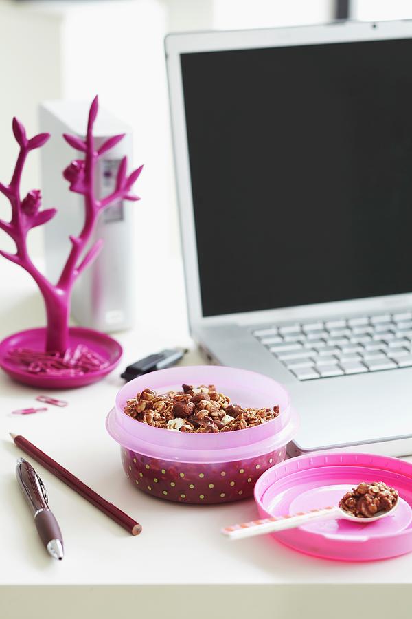 Muesli In A Pink Spotted Tupperware Box Next To A Laptop Photograph by Charlotte Tolhurst