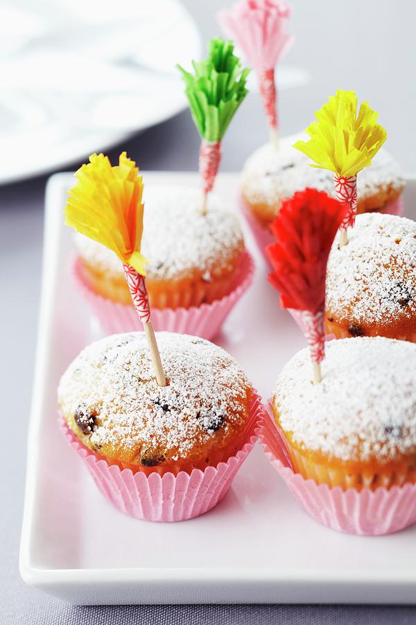 Muffins Dusted With Icing Sugar And Decorated With Frilled Cocktail Sticks Made From Paper Cake Cases Photograph by Franziska Taube