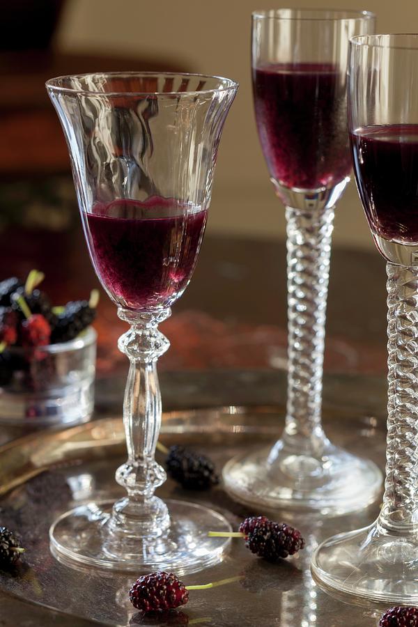 Mulberry Liqueur In Three Stemmed Glasses On A Tray Photograph by Katharine Pollak