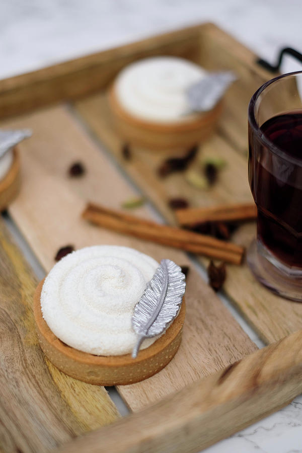 Mulled Wine Tarts Topped With Cream And Decorated With A Silver Feather Photograph by Marions Kaffeeklatsch
